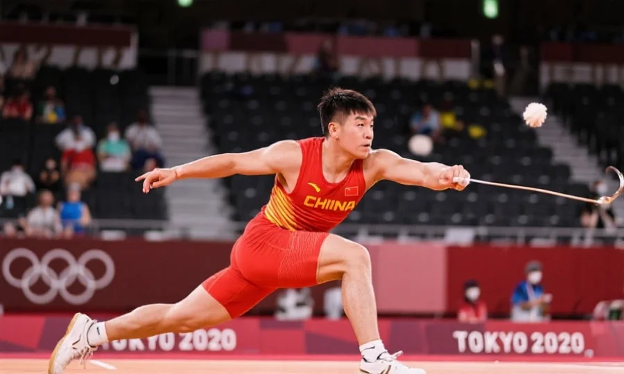 中国运动员在奥运会赛场奋力拼搏,专注神情与动作定格,背景为观众席和奥运标志